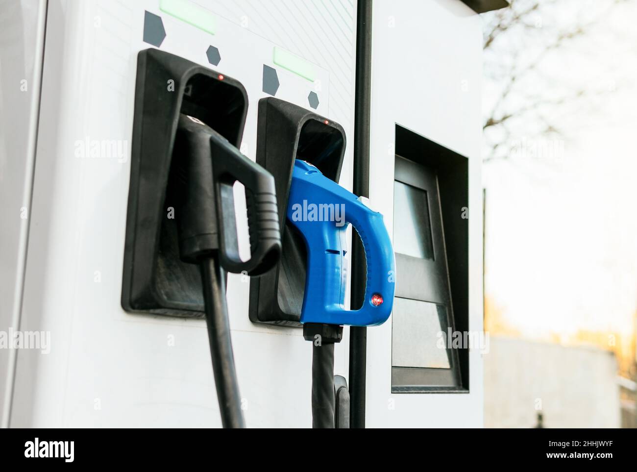 White charging point with two connections in city parking lot with no