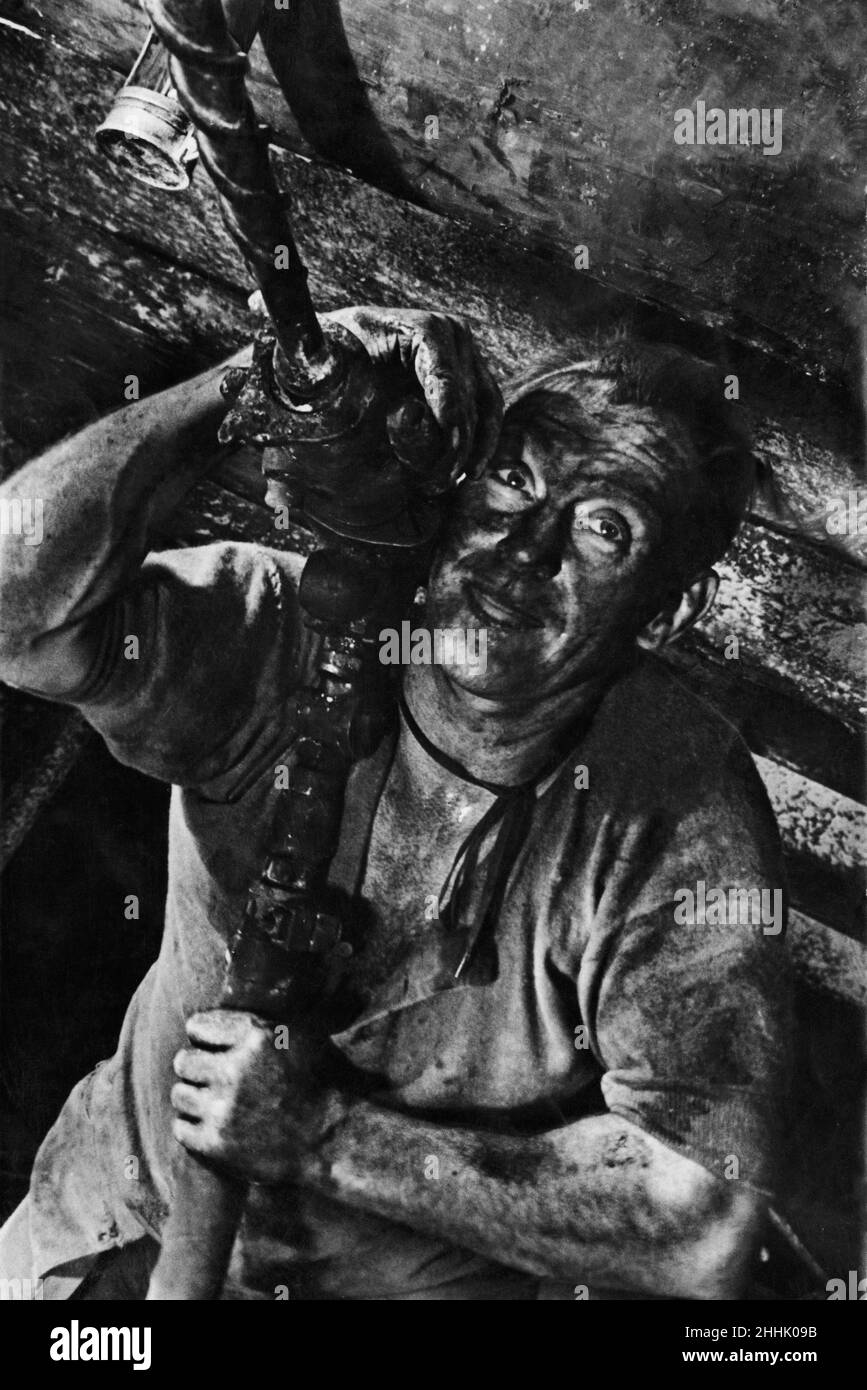 The shot hole driller looks like a modern Hercules in modern industry, Daily Mirror Published Picture Wednesday 15th May 1935, Pages 16 & 17.  Captioned :   The shot hole driller, a true Hercule; of modern industry. This fine study was made far below the surface at the Astley Green Collieries of the Manchester Collieries, Ltd., where the second of our series of pictures illustrating the other man's job should the work of the men in Britain's coal mines, vital source of the nation's wealth and might, Upon this country's rich coal deposits are founded our great engineering industries. Coal drive Stock Photo