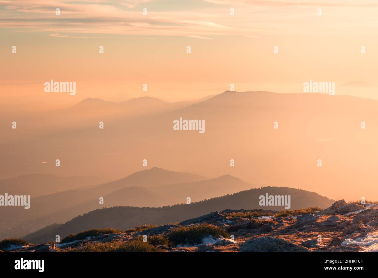 Spectacular view of famous Sierra de Guadarrama range covered with fog against cloudy sky located in Spain on winter day Stock Photo