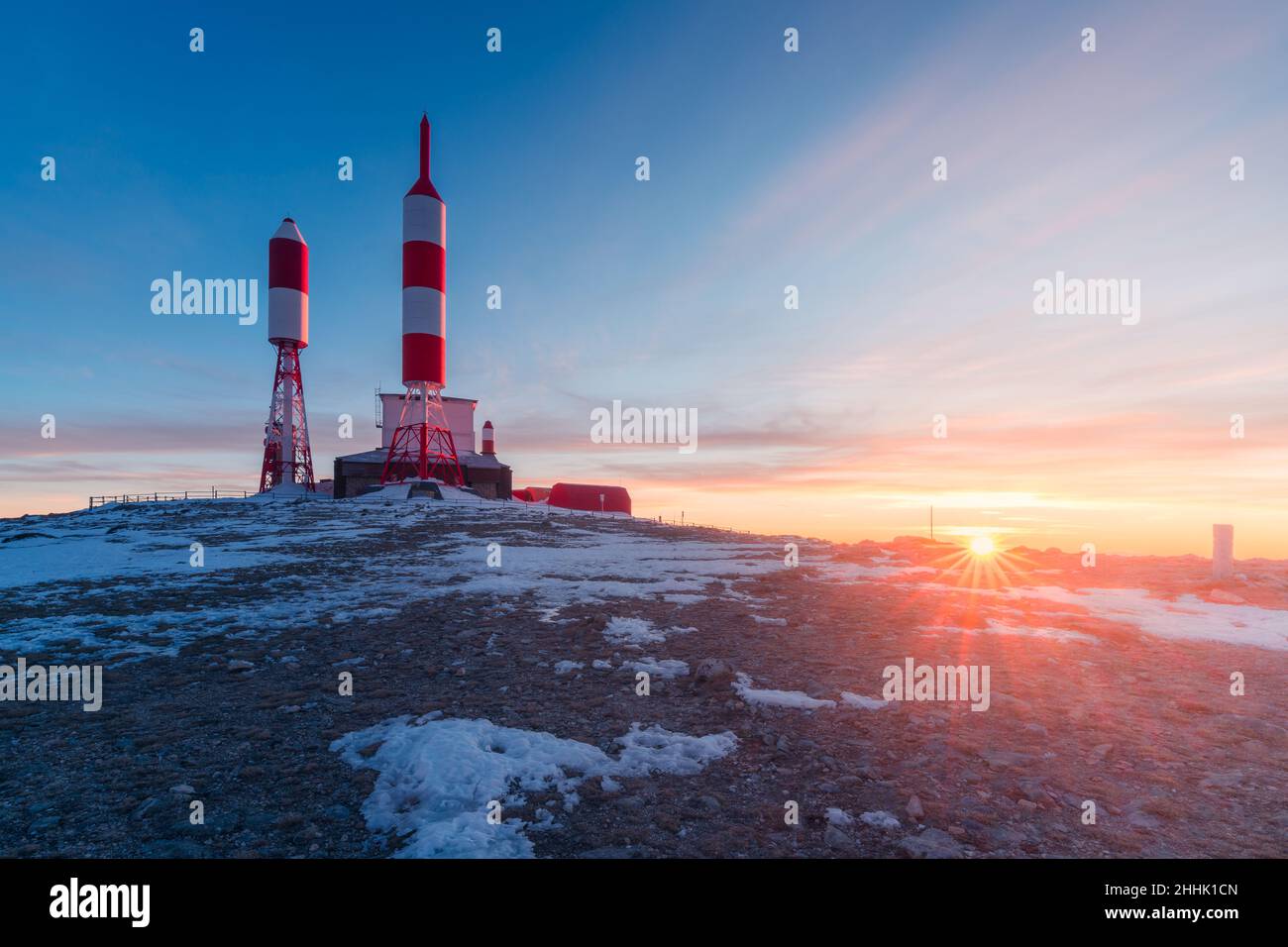 Station with radio and television signal repeater antennas with curious rocket shape located on snowy mountain on winter day in Spain Stock Photo