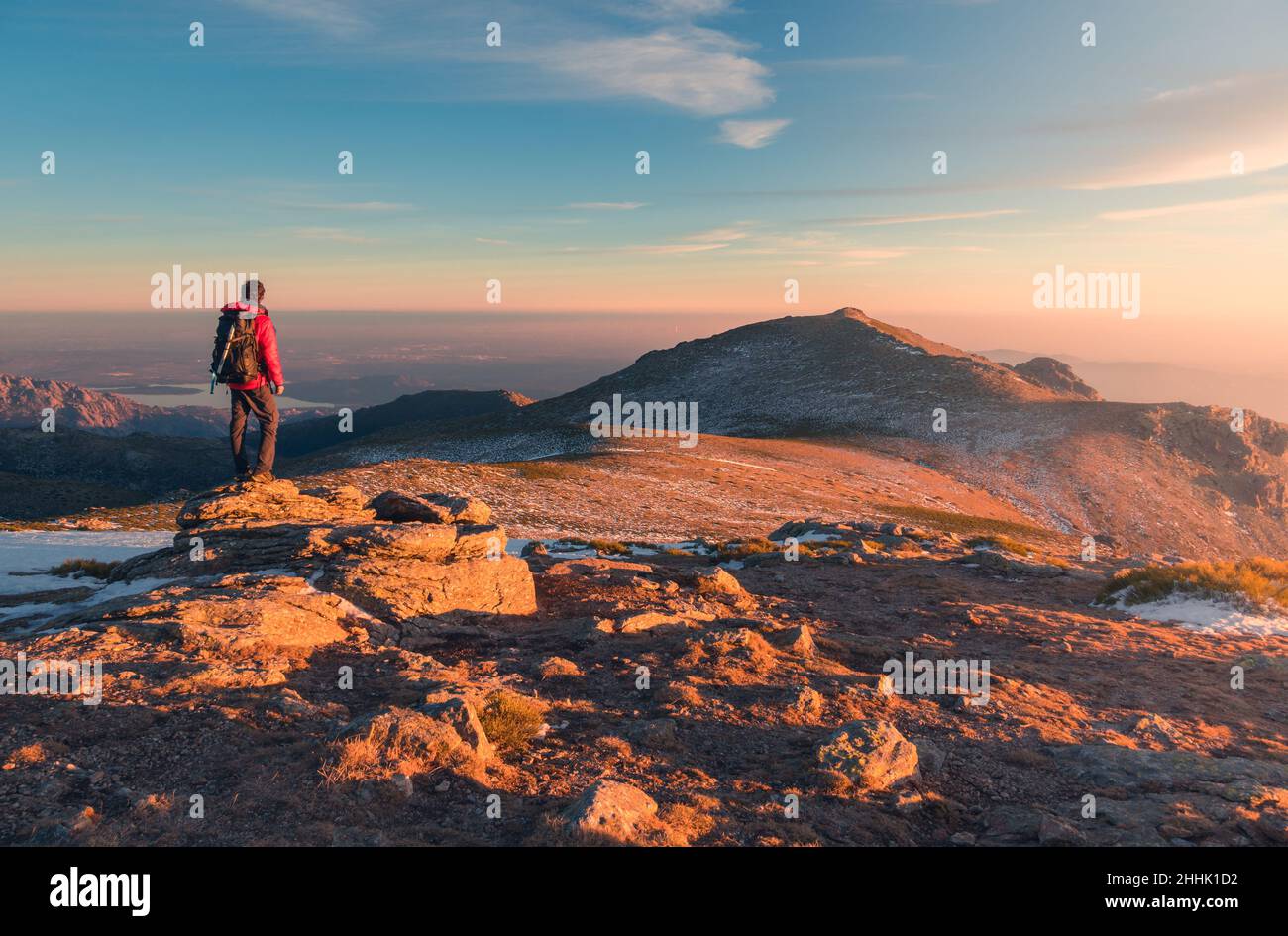 Back view of distant anonymous hiker standing on Sierra de Guadarrama mountain range during trekking in Spain on winter day Stock Photo