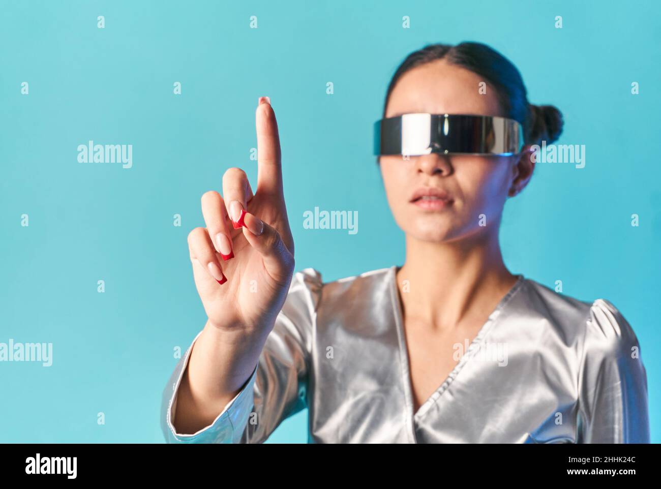 Stylish young ethnic lady with dark hair in trendy mirrored VR glasses  touching invisible screen with finger while experiencing virtual reality  agains Stock Photo - Alamy