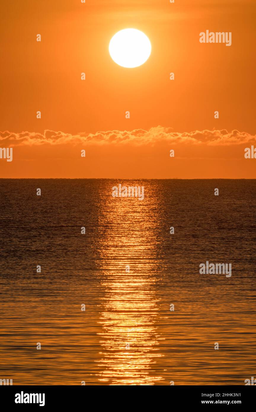 Blazing sunrise in orange sky over ocean Stock Photo - Alamy