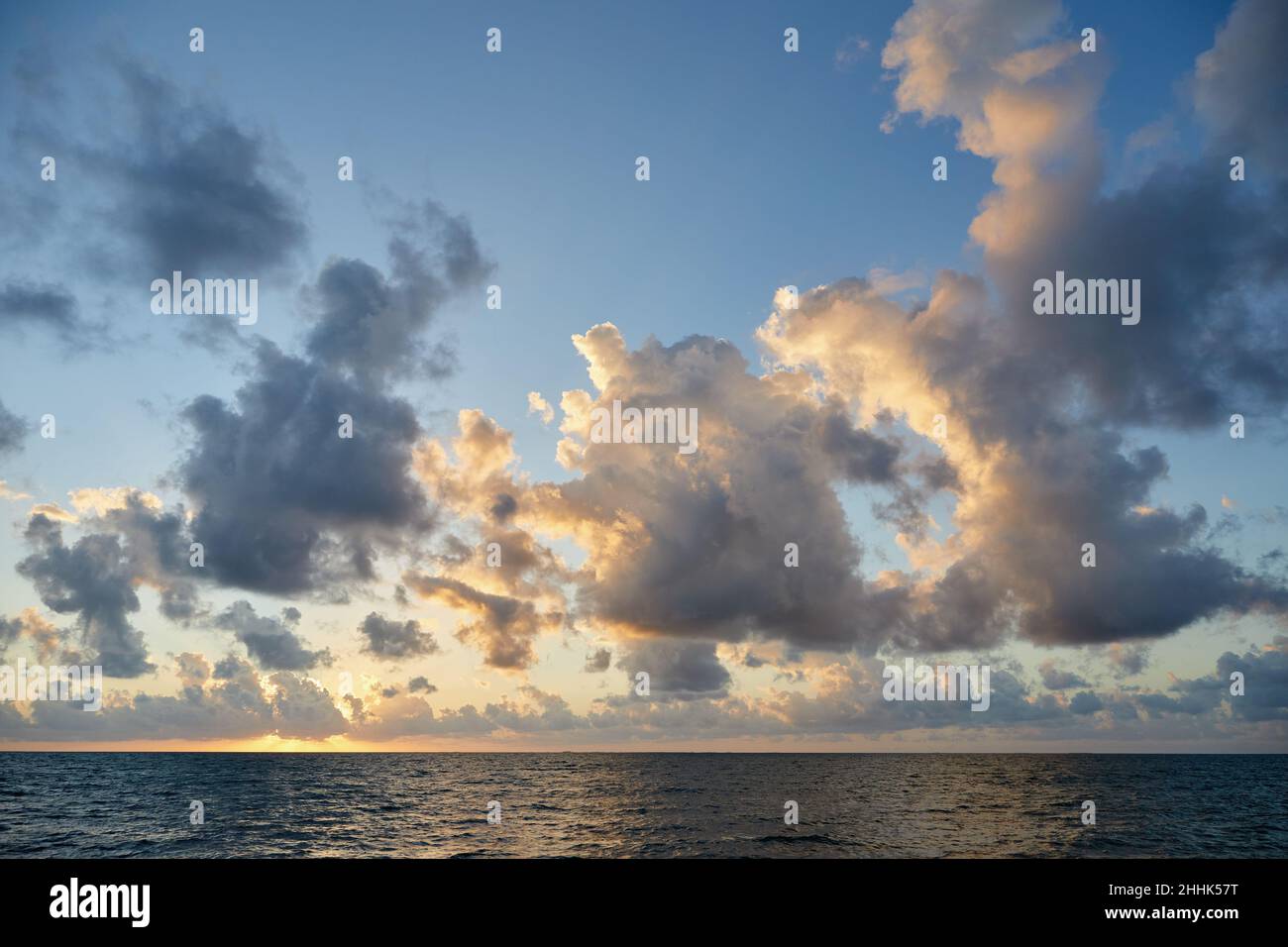 Clouds over ocean at sunrise Stock Photo - Alamy