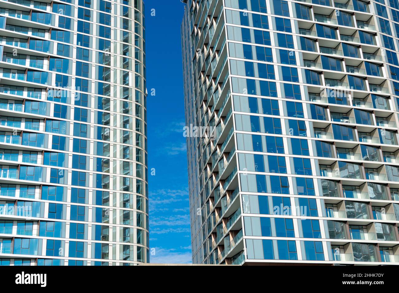 Glass facade of two modern residential high rise buildings. Blue sky ...