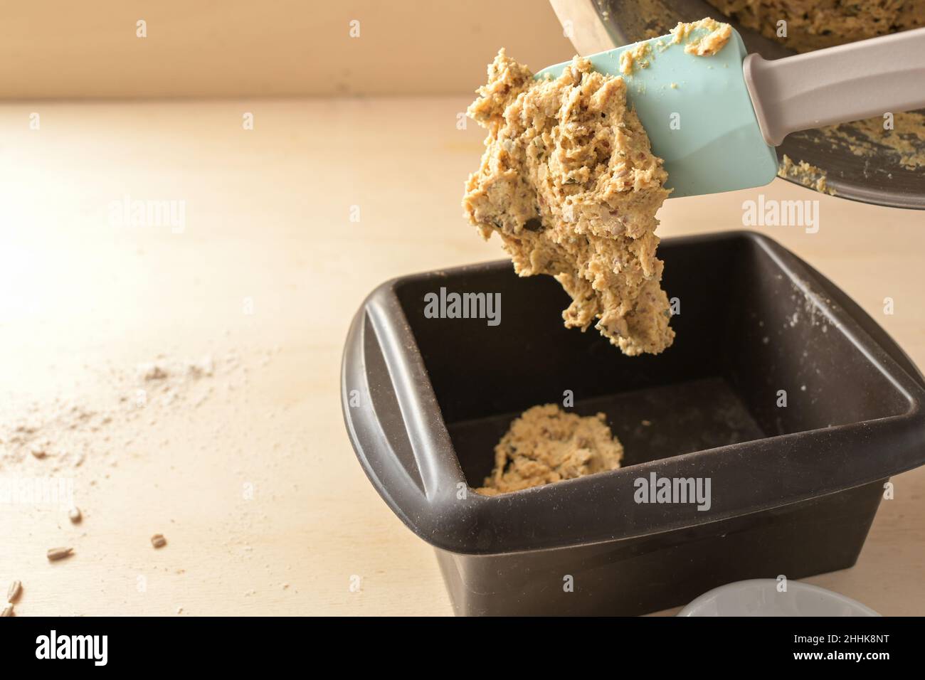 https://c8.alamy.com/comp/2HHK8NT/homemade-bread-dough-from-whole-grain-flour-with-seeds-is-poured-from-the-mixing-bowl-into-a-silicone-baking-mold-healthy-recipe-copy-space-selecte-2HHK8NT.jpg