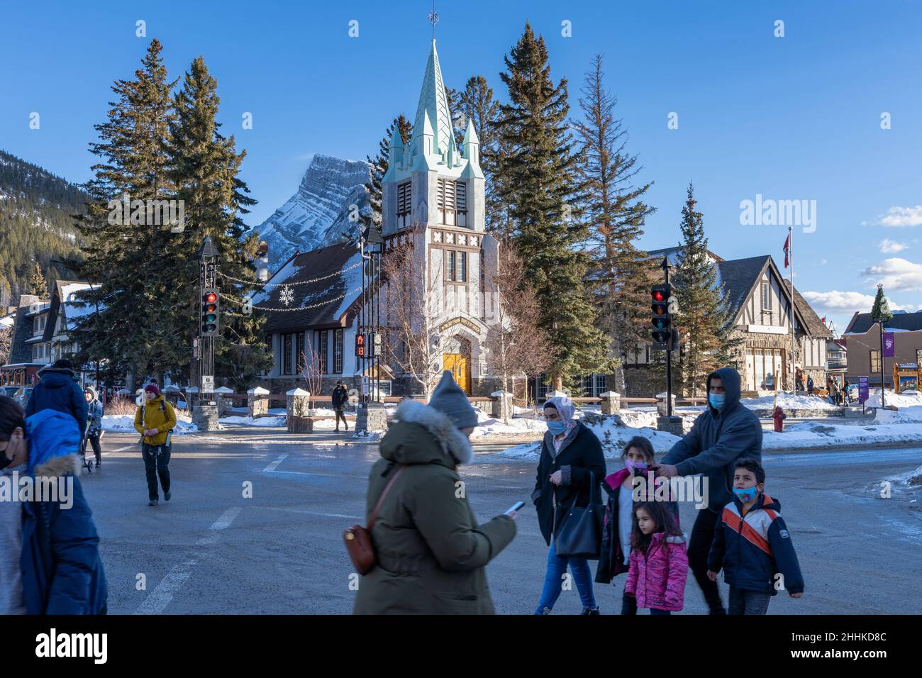 Banff, Alberta, Canada - January 23 2022 : Downtown Banff Avenue in winter. Pedestrians are crossing the road during covid-19 pandemic period. Stock Photo