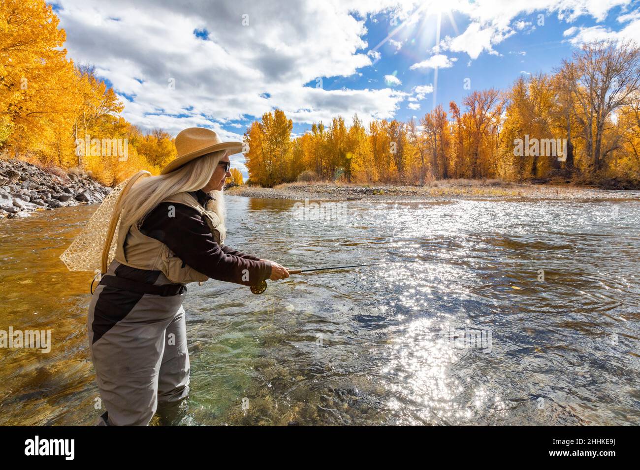 USA, Idaho, Bellevue, Senior woman fly-fishing in Big Wood River in autumn Stock Photo