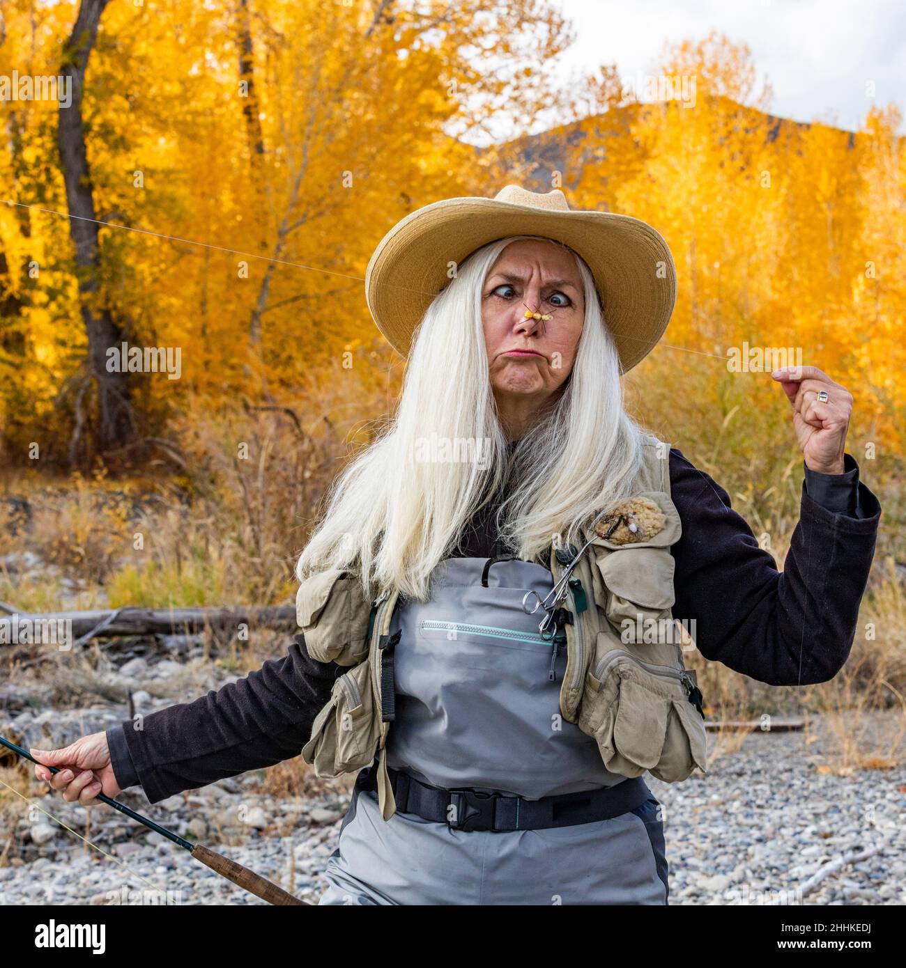 USA, Idaho, Bellevue, Senior woman holding fishing rod and making faces Stock Photo