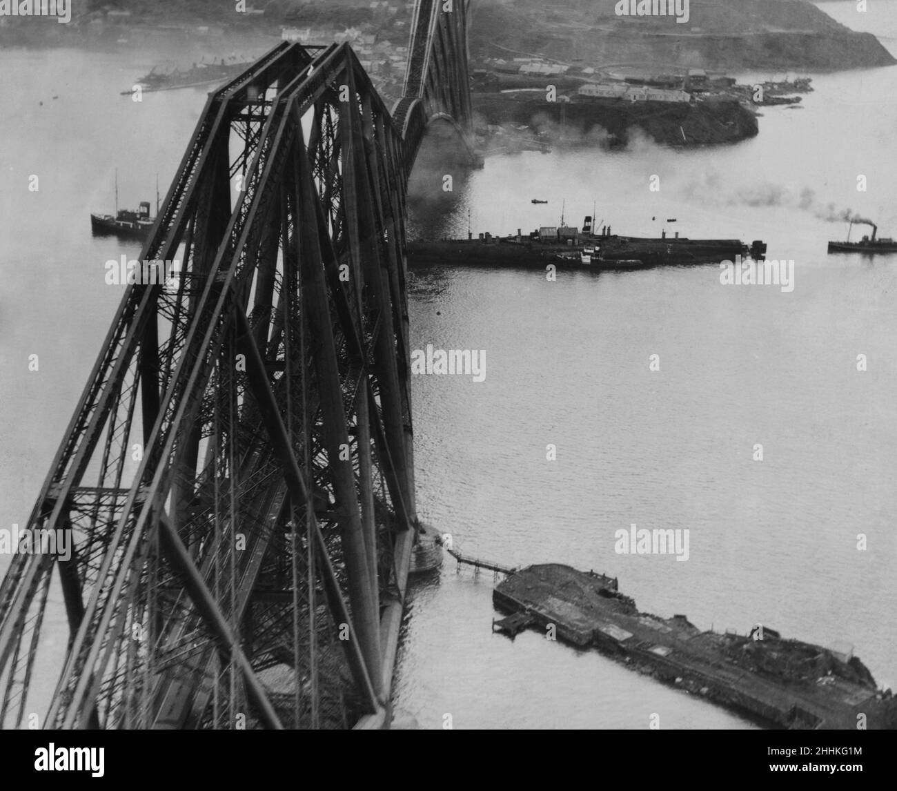 A picture taken from one of the S.M.T Travel Aerial Travel cabin moth planes when the former German battleship SMS Prinzregent Luitpold was being manoeuvred under the Forth Bridge on the way to Rosyth to be broken up. 12th May 1933. Stock Photo