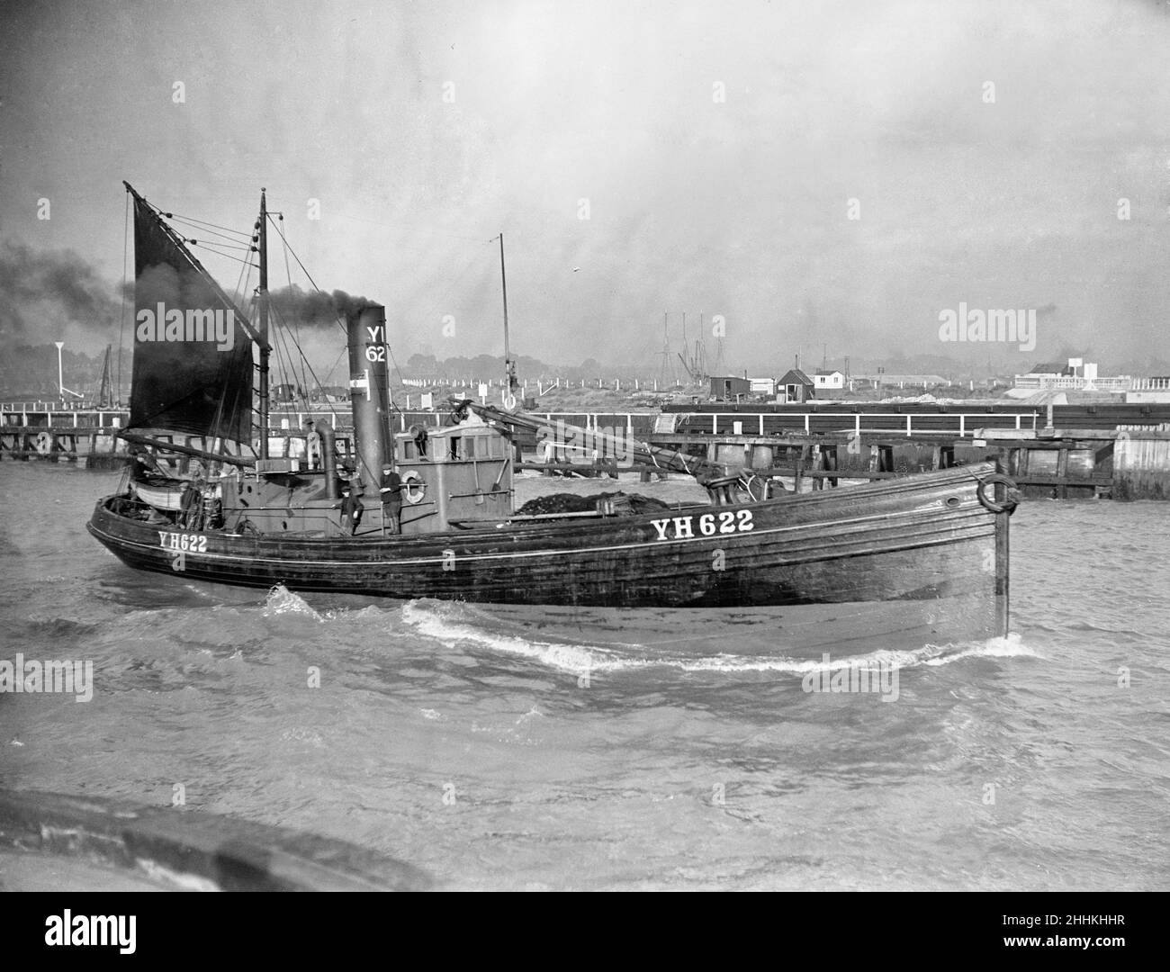 A Yarmouth Herring boat leaves the mouth of the River Yar Norfolk for a fishing trip in the North Sea Fishing Fishing Industry Water Sea Drifter Harbour Circa 1935 Stock Photo