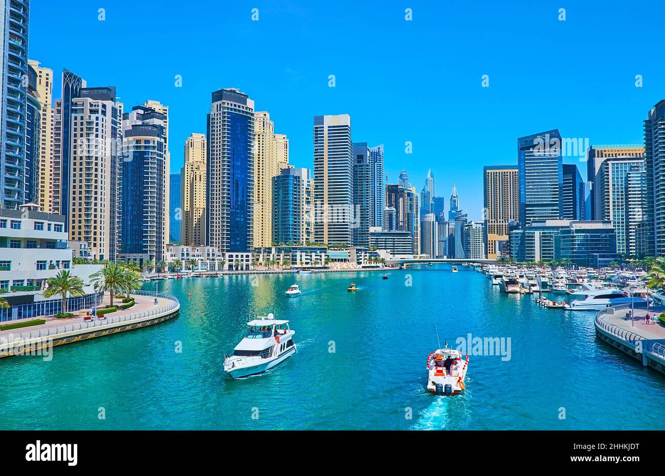 The boats floating along Dubai Marina, surrounded with forest of futuristic skyscrapers, Dubai, UAE Stock Photo