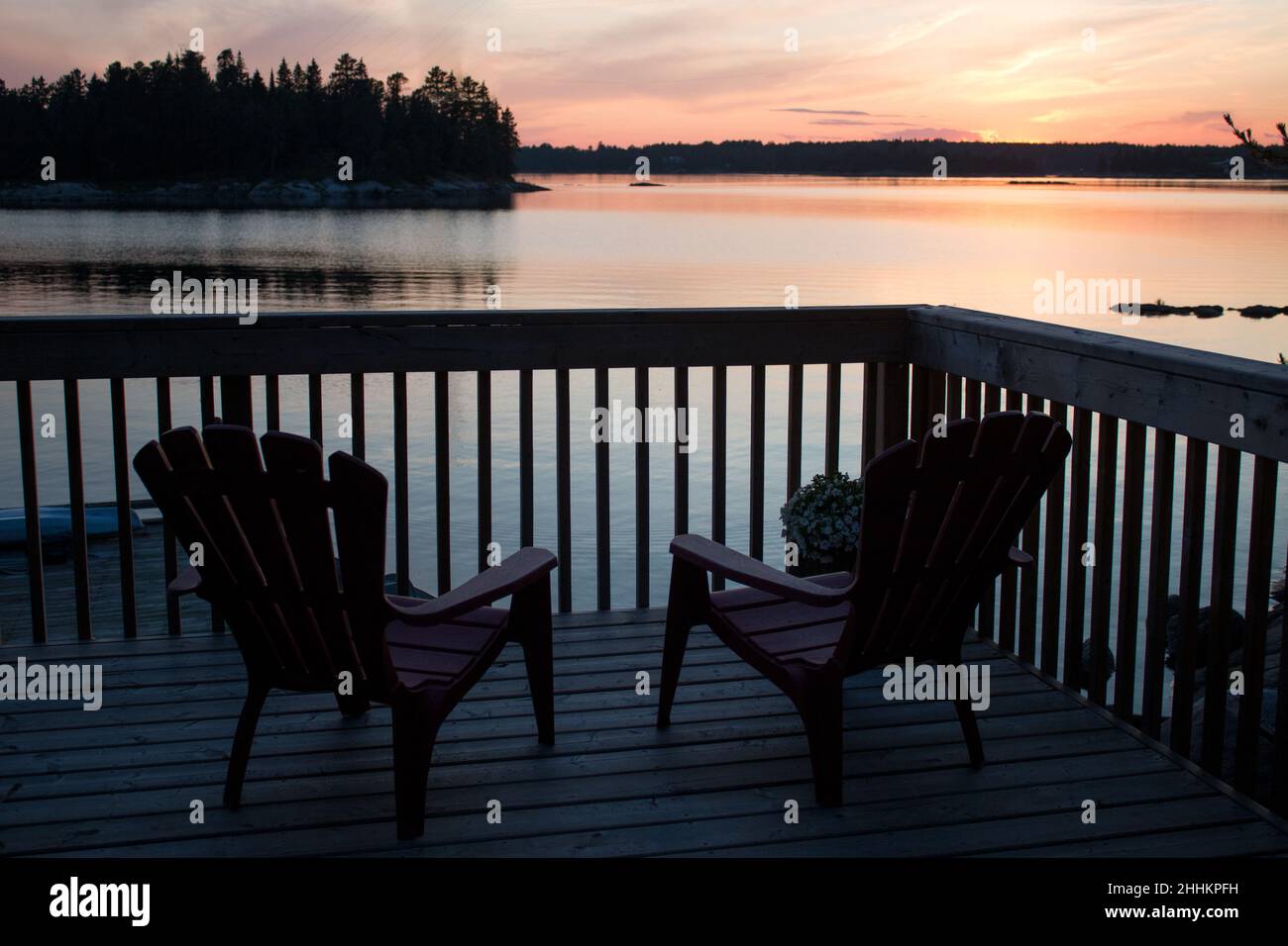 Watching the sunset from the deck chairs overlooking the river Stock Photo