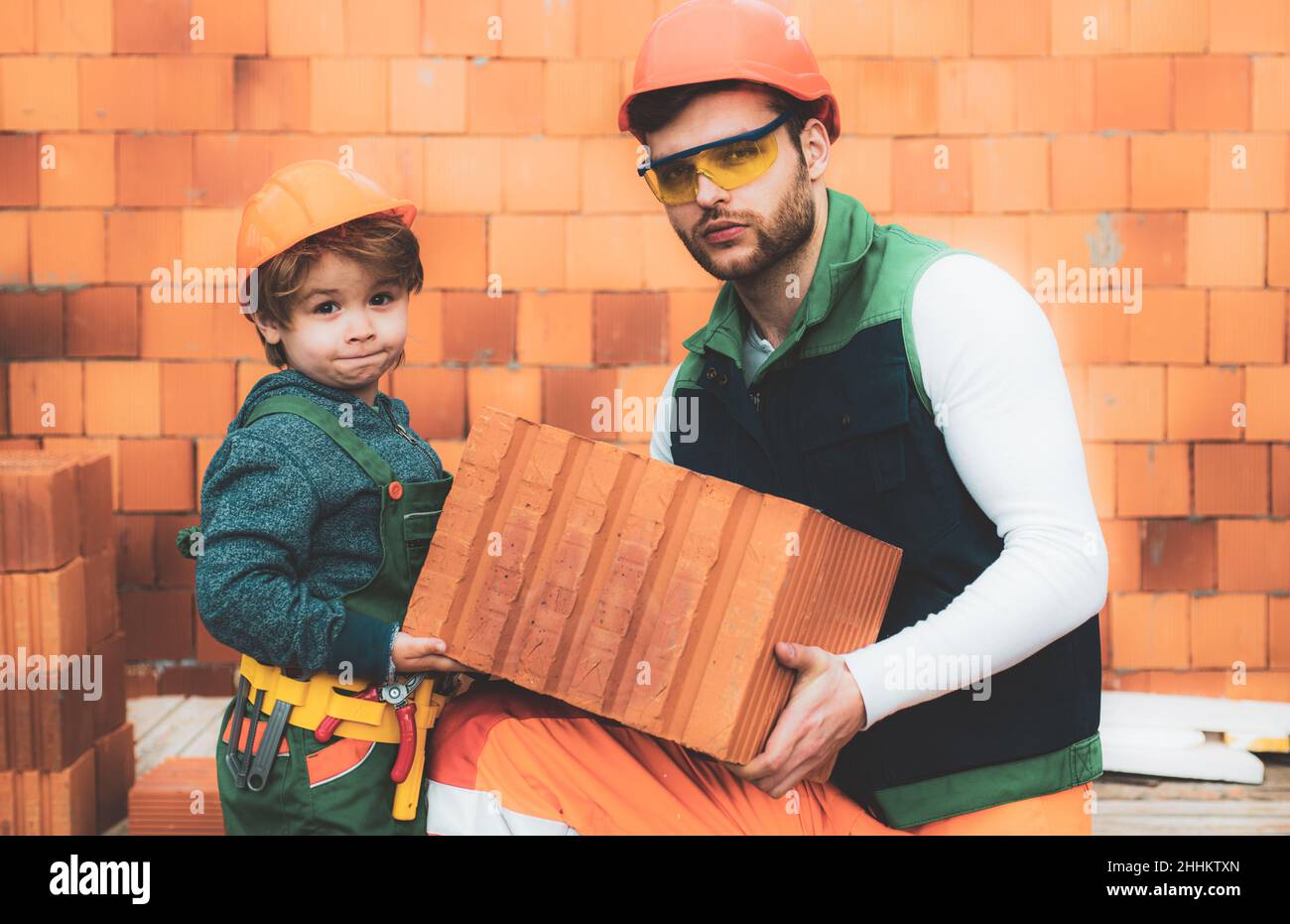 Brothers bricklayers make masonry, builders work with brick layer Stock