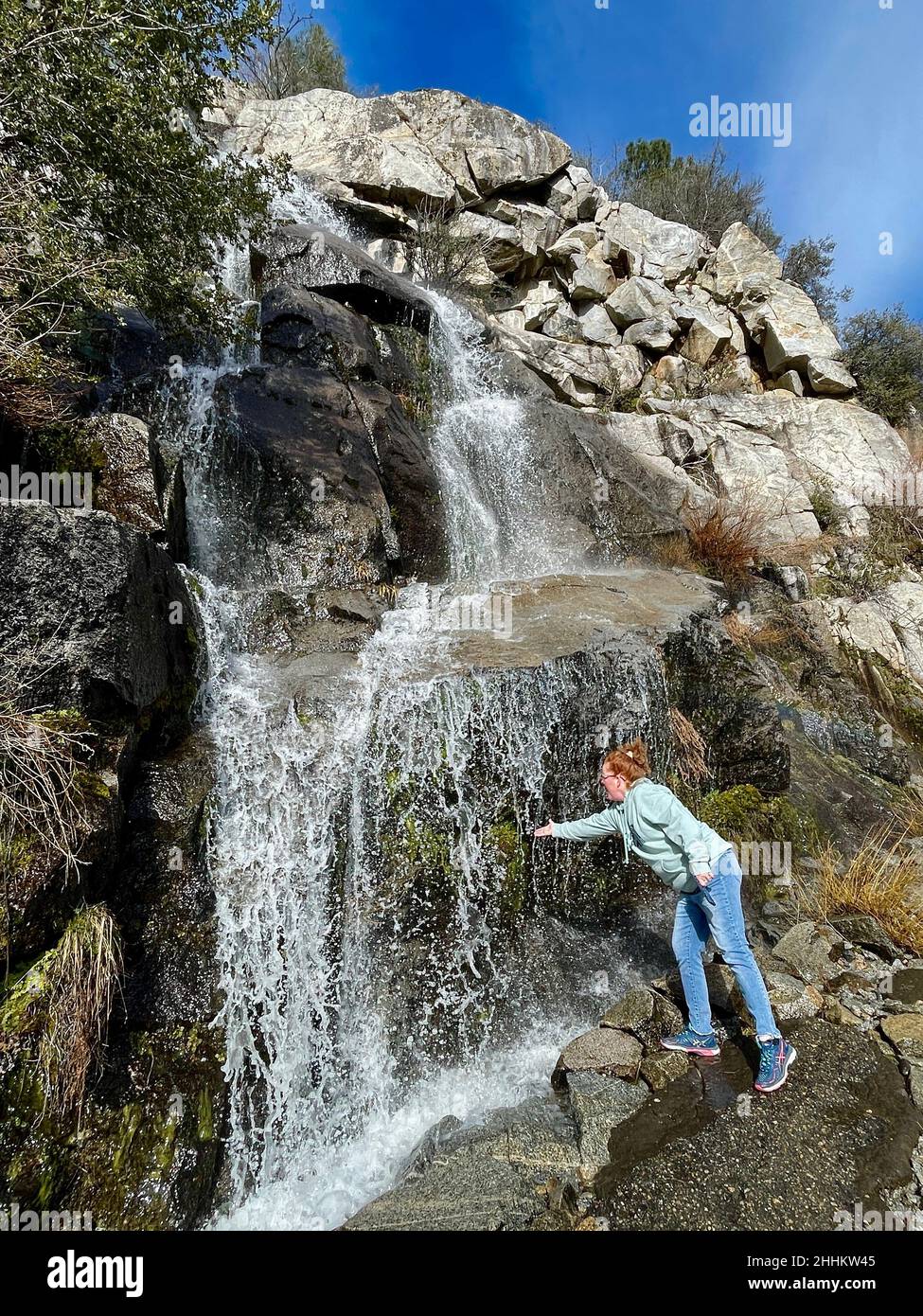 Yosemite National Park, CA, U.S.A. 24th Jan, 2022. Jennifer Bicek stops at the Tueeulala Falls as she walks the 2.5 hike to the Wapama Falls. The Hetch Hetchy Reservoir has a picture perfect hike around the north side of the reservoir. (Credit Image: © Marty Bicek/ZUMA Press Wire) Stock Photo