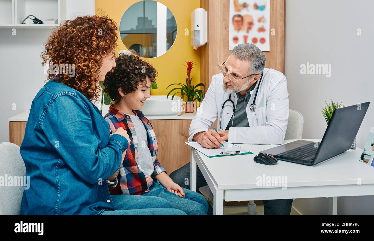 Friendly pediatrician communicate with her child patient at doctor's office while pediatrician consultation. Kid health Stock Photo