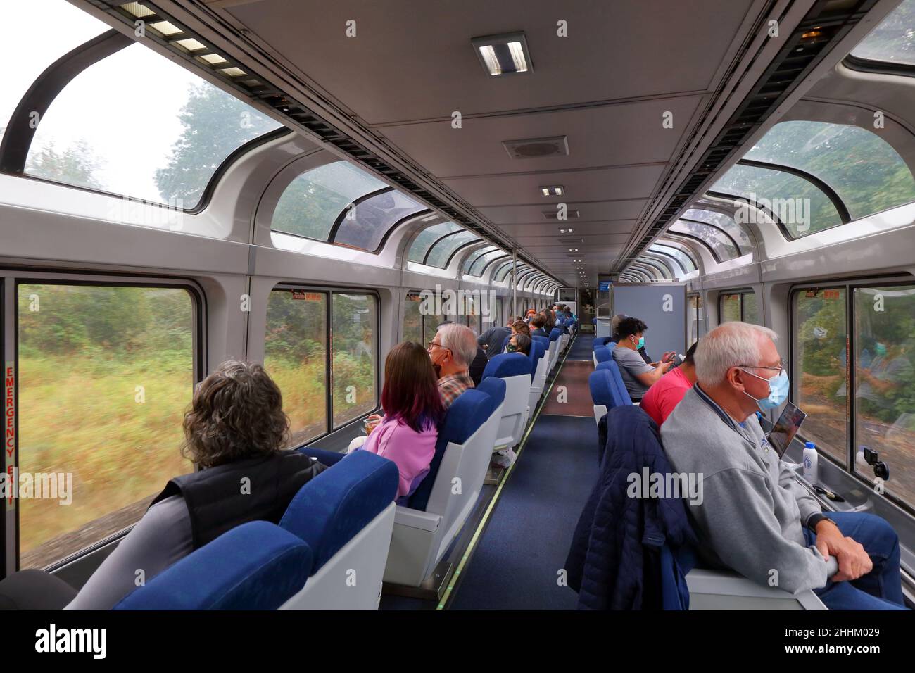 People looking out the windows from inside an Amtrak Observation Car, sightseer lounge car, on the Coast Starlight route between Seattle and Portland Stock Photo