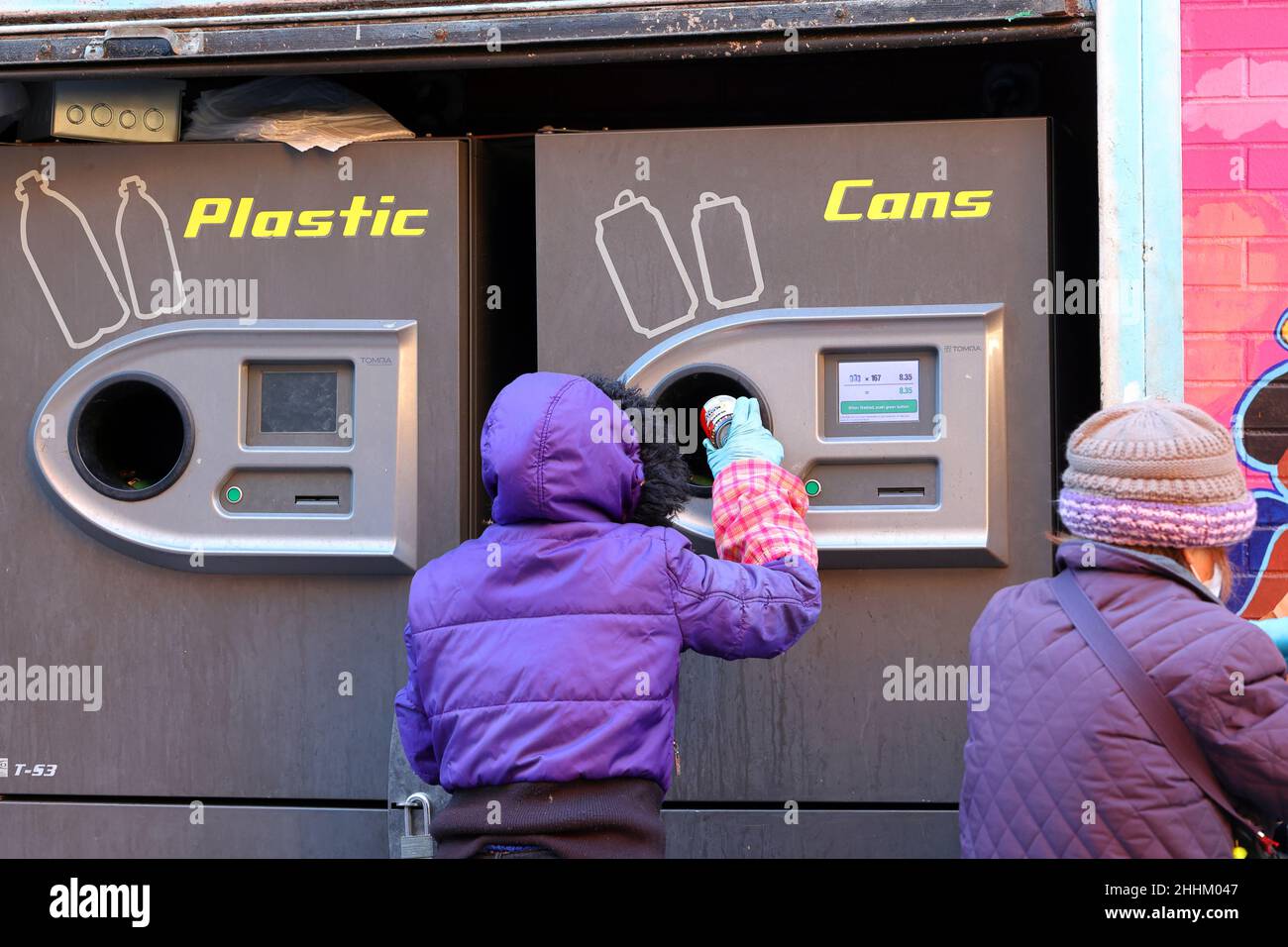A person using a Tomra T-53 'reverse vending machine' to redeem recyclable bottles and cans for its bottle deposit money in New York City. Stock Photo