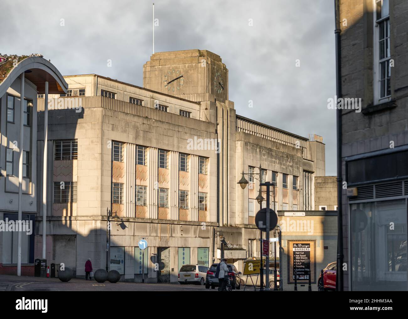 Run down old department store shop closed on city high street in town centre 1950's art deco styling clock tower, boarded up shut down no customers Stock Photo