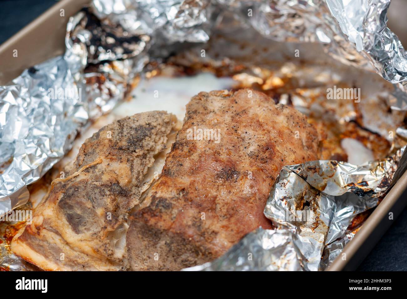 roasted chicken wrapped in aluminium foil, indoor closeup Stock Photo