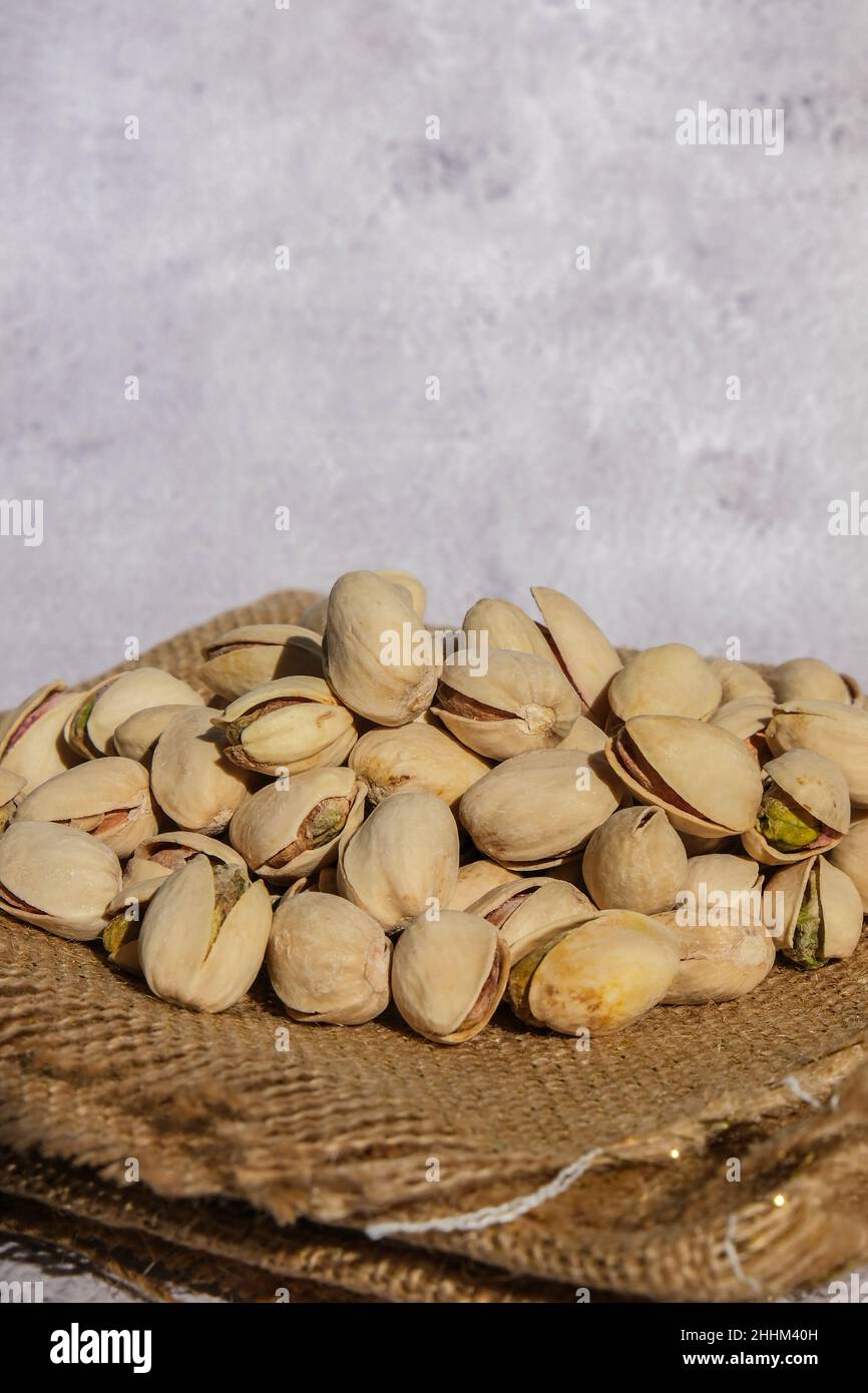 Pistachios in burlap sack on concrete table. Organic pistachios. Vegan