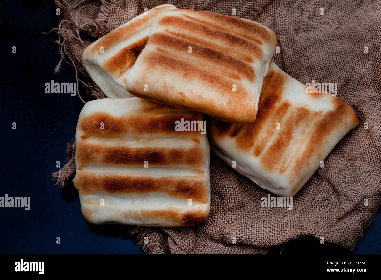traditional South African griddle bread or roosterkoek on rustic surface with copy space Stock Photo