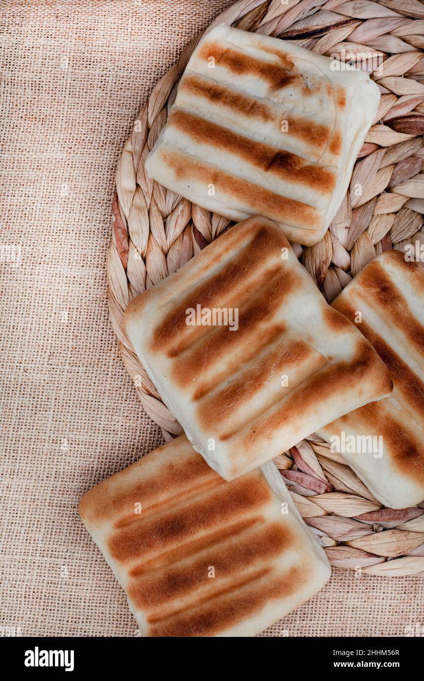 traditional South African griddle bread or roosterkoek on rustic surface with copy space Stock