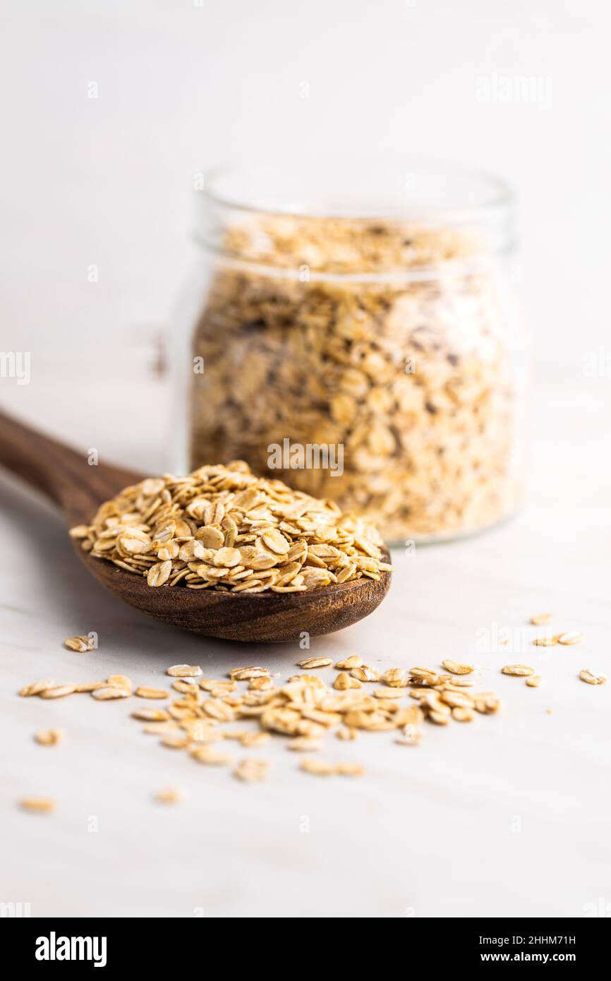 Breakfast cereals. Uncooked oatmeal. Raw oat flakes in wooden spoon. Stock Photo