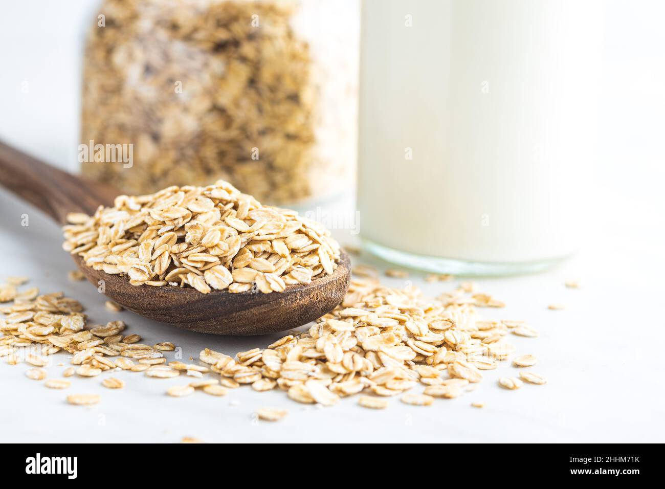 Breakfast cereals. Uncooked oatmeal. Raw oat flakes in wooden spoon. Stock Photo