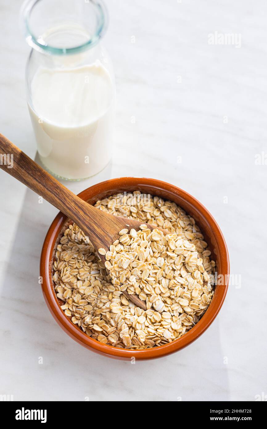 Breakfast cereals. Uncooked oatmeal. Raw oat flakes in bowl. Top view. Stock Photo