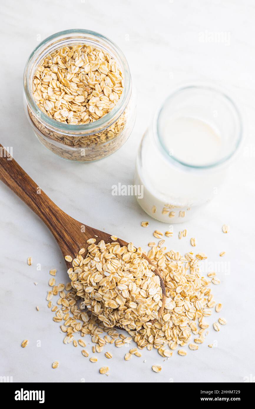 Breakfast cereals. Uncooked oatmeal. Raw oat flakes in wooden spoon. Top view. Stock Photo