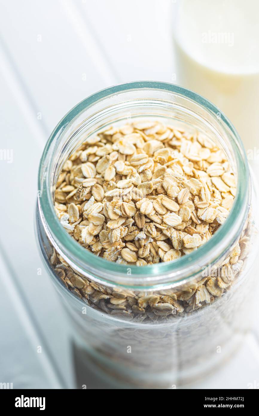 Uncooked oatmeal. Raw oat flakes in jar. Stock Photo