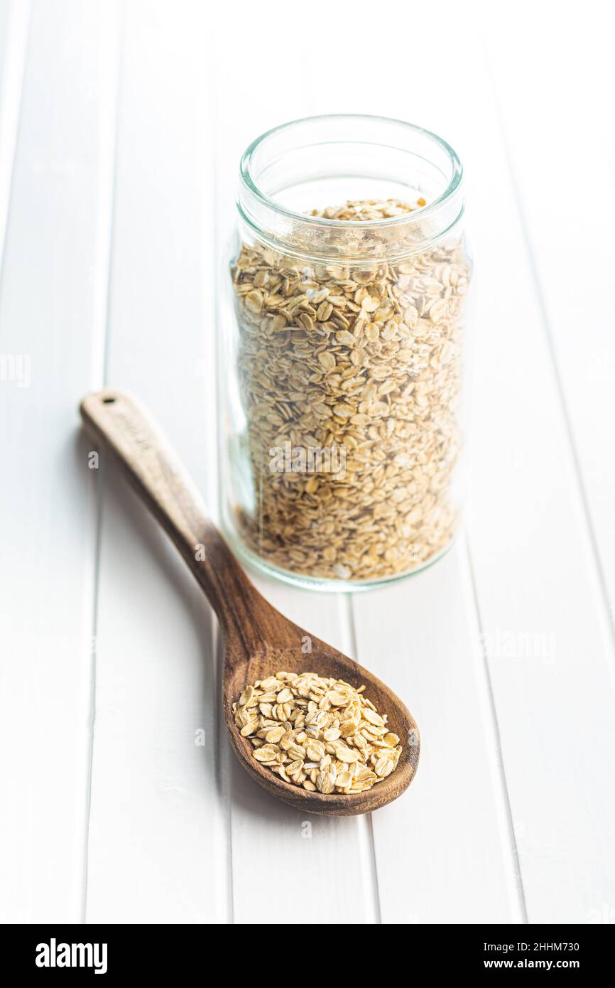 Uncooked oatmeal. Raw oat flakes in wooden spoon. Stock Photo