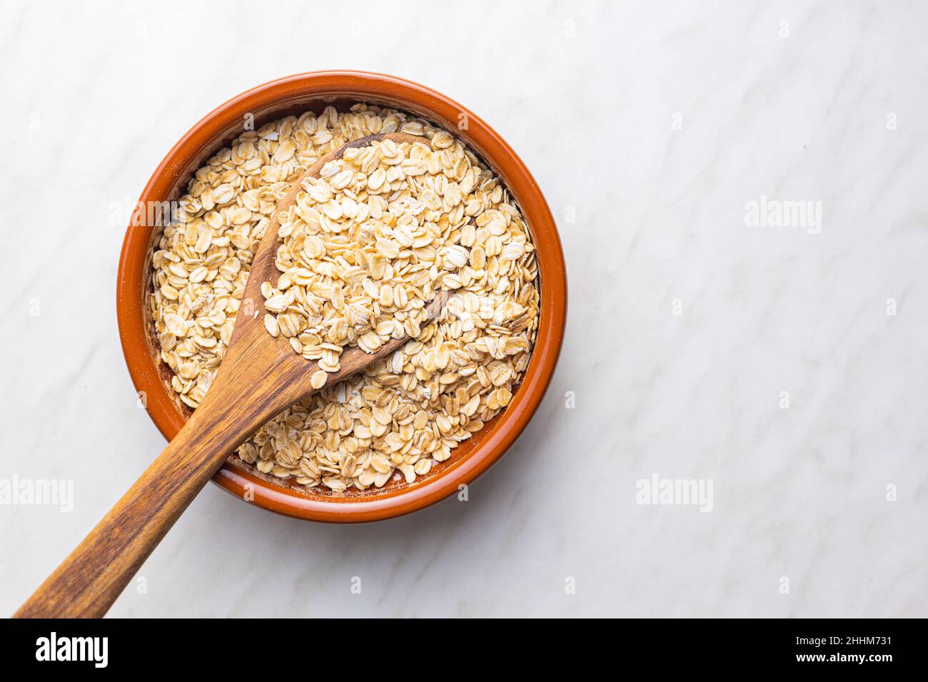 Breakfast cereals. Uncooked oatmeal. Raw oat flakes in bowl. Top view. Stock Photo