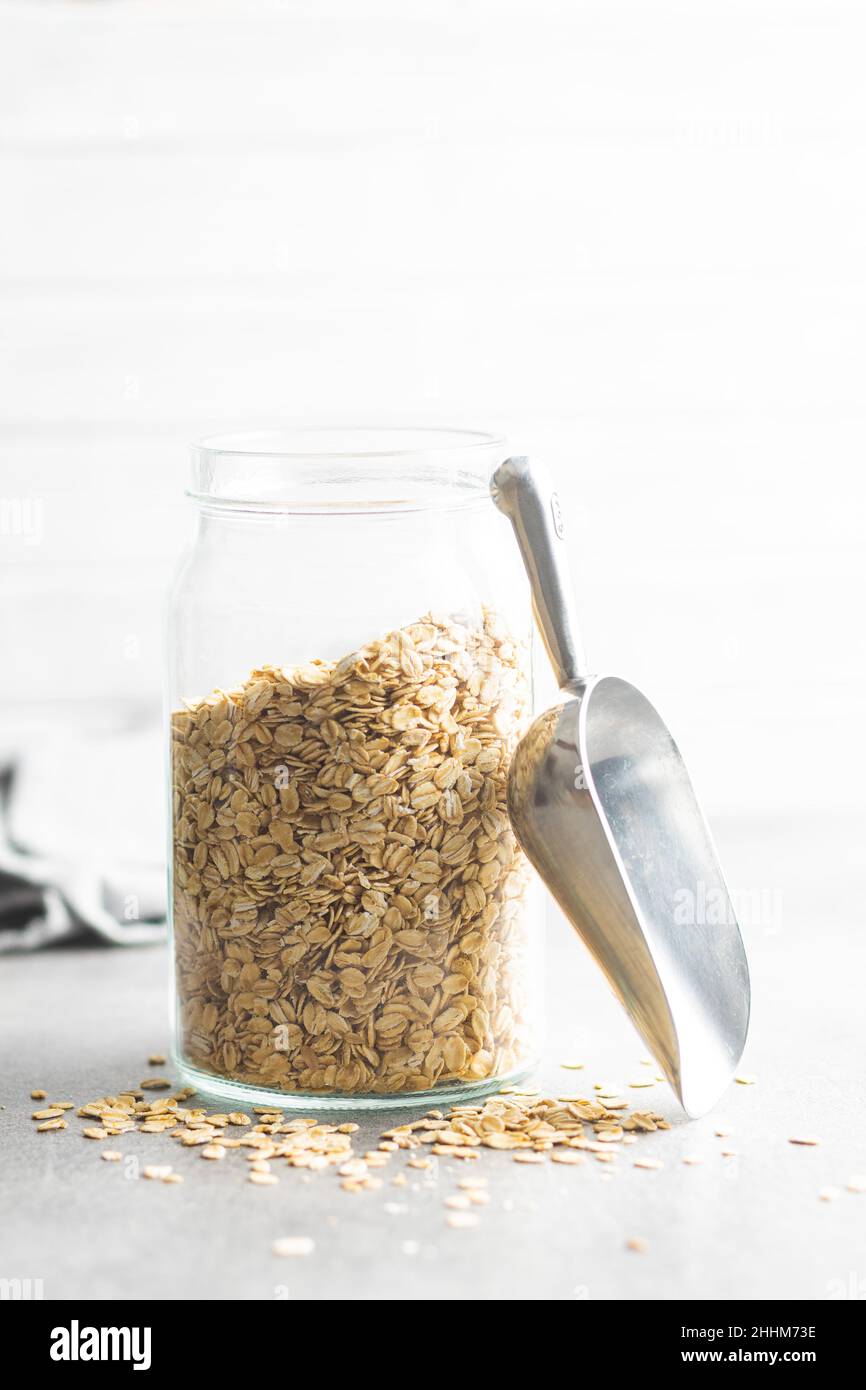 Breakfast cereals. Uncooked oatmeal. Raw oat flakes in jar. Stock Photo