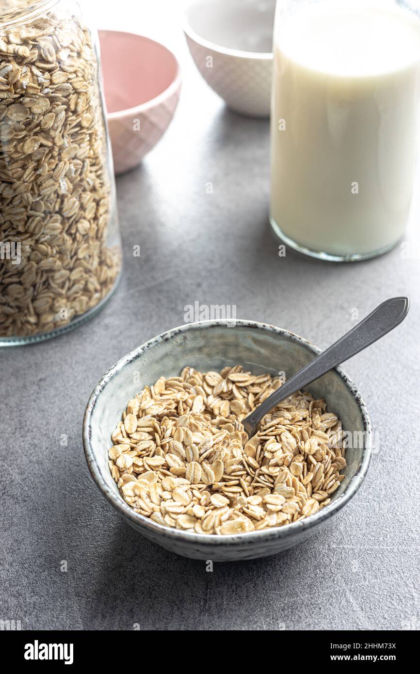 Breakfast cereals. Uncooked oatmeal. Raw oat flakes in bowl. Stock Photo