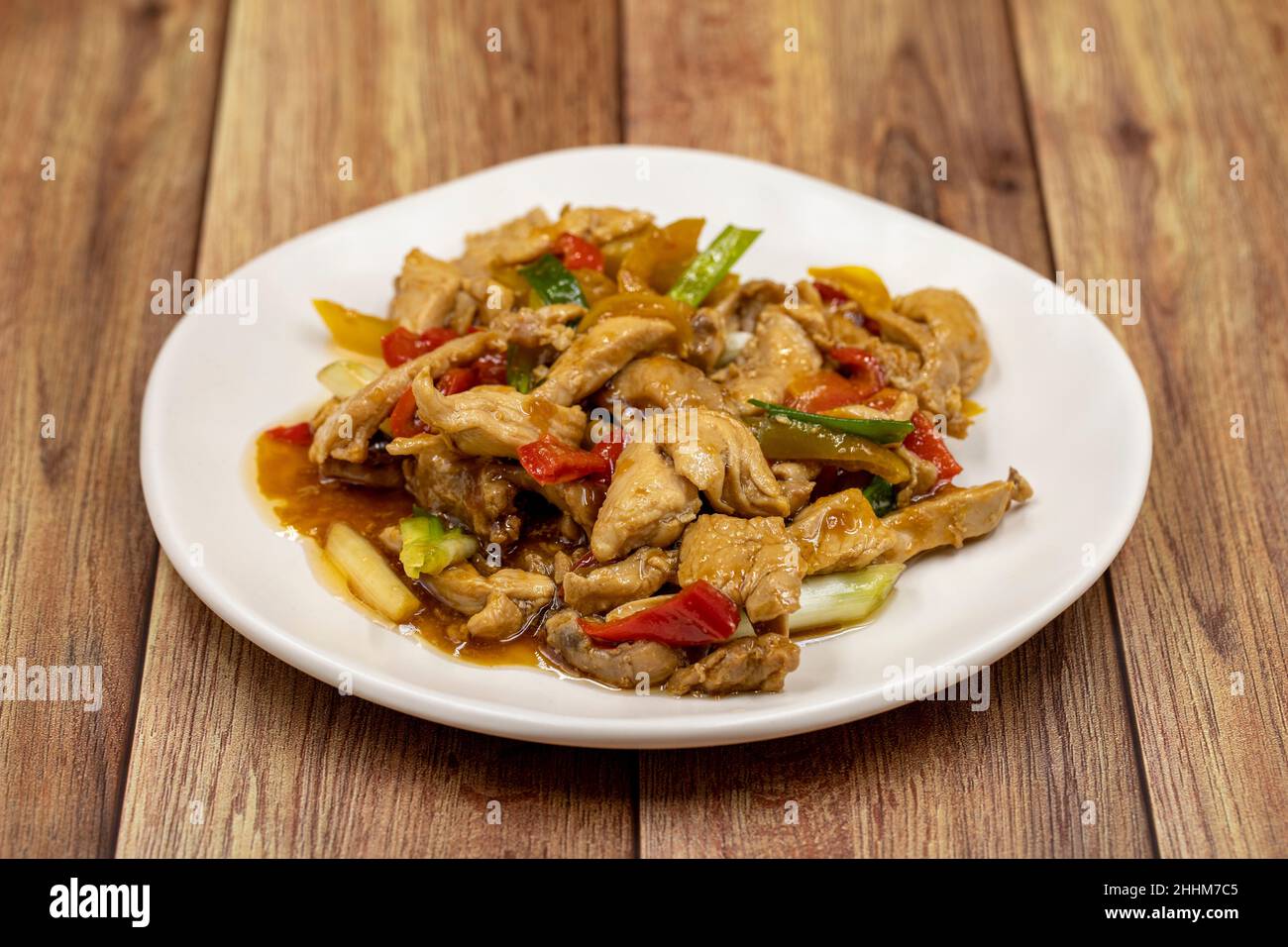 Chinese chicken dish. Chicken with olive oil and soy sauce. Traditional Chinese dish prepared with garlic, onion, capia pepper and green pepper Stock Photo