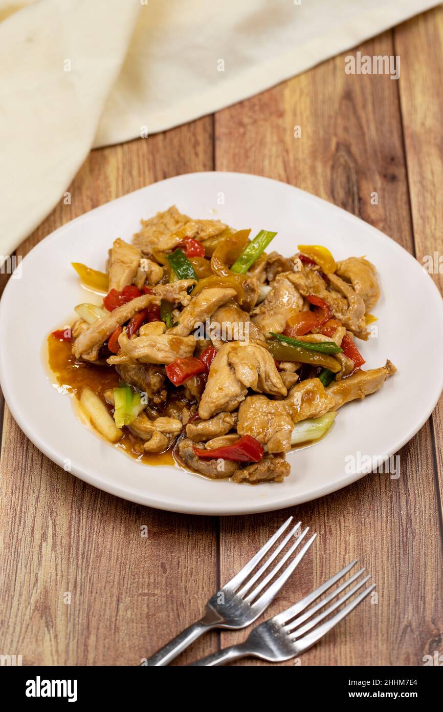 Chinese chicken dish. Chicken with olive oil and soy sauce. Traditional Chinese dish prepared with garlic, onion, capia pepper and green pepper Stock Photo