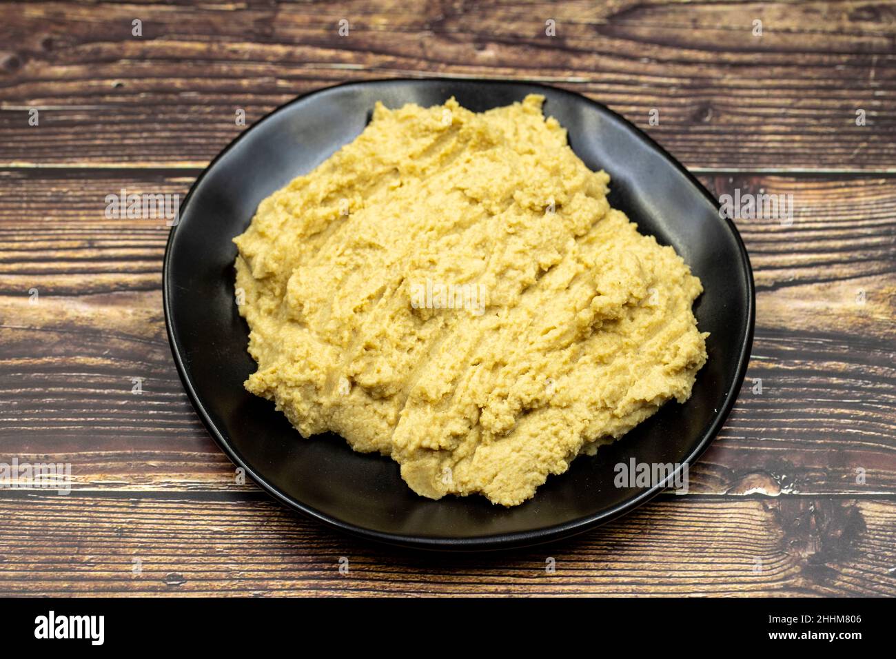 Hummus in a ceramic plate. Dishes of chickpeas, a vegetarian dish. Stock Photo