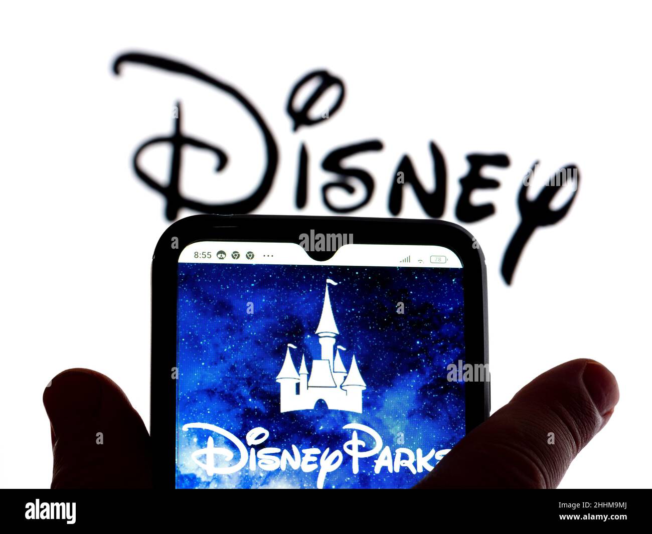 In this photo illustration, the Disney parks logo is seen displayed on a smartphone screen with a Disney logo in the background. Stock Photo