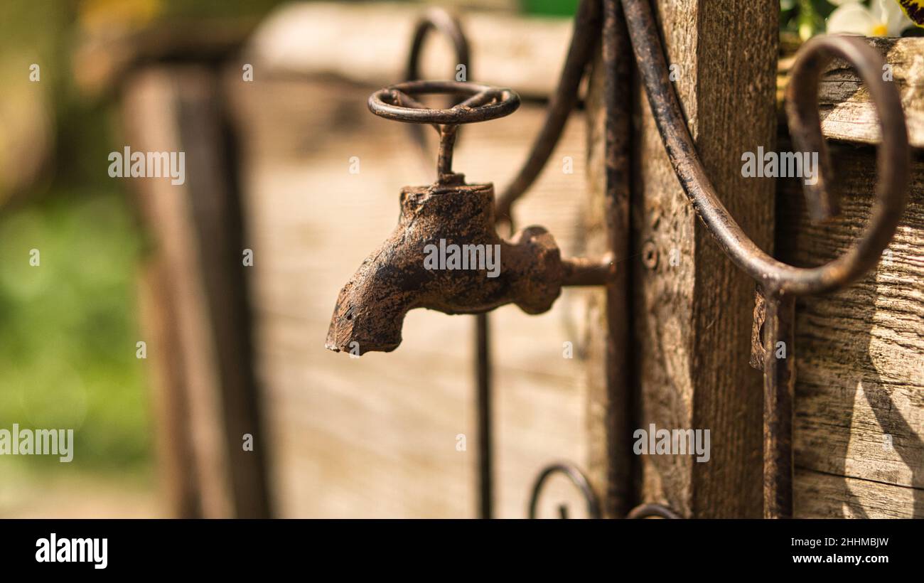 Faucet as deco in old with rust on a wooden board. Detailed and textured decoration Stock Photo