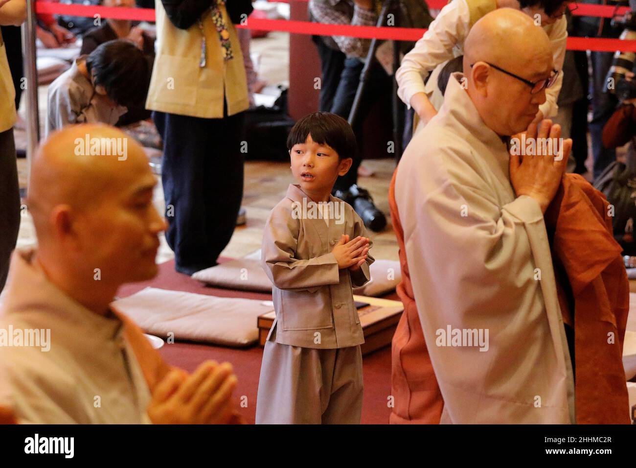 May 2, 2018-Seoul, South Korea-A child gets his head shaved by a Buddhist monk during the 'Children Becoming Buddhist Monks' ceremony forthcoming buddha's birthday at a Chogye temple in Seoul, South Korea. Children have their hair shaved off during the 'Children Becoming Buddhist Monks' ceremony ahead of buddha's birthday at a Chogye temple. The children will stay at the temple to learn about Buddhism for 20 days. Buddha was born approximately 2,562 years ago, and although the exact date is unknown, Buddha's official birthday is celebrated on the full moon in May in South Korea, which is on Ma Stock Photo