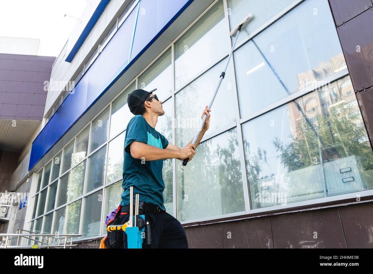 Male professional cleaning service worker in overalls cleans the ...