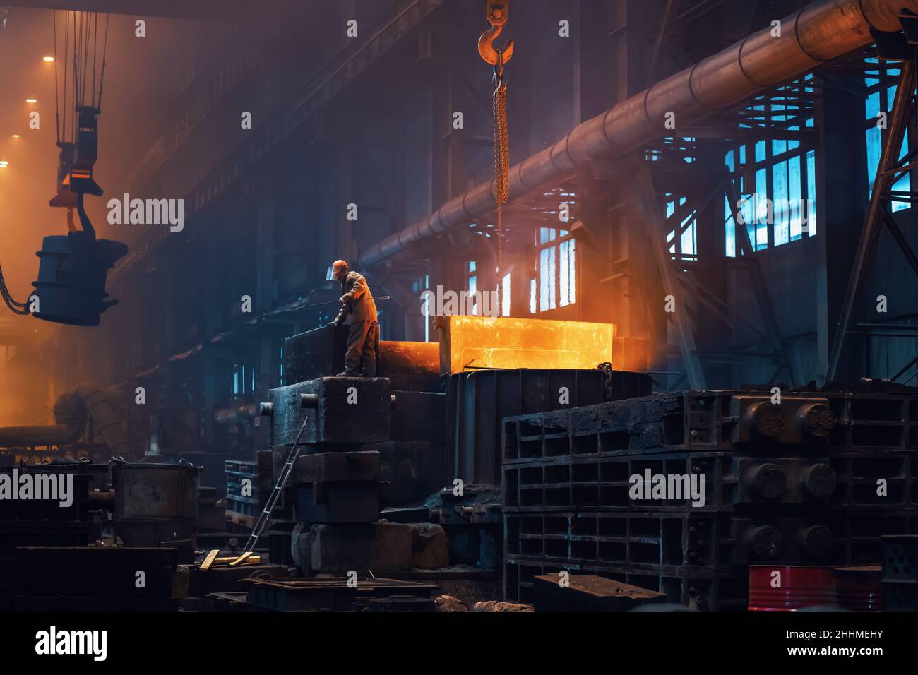 Metallurgy plant interior. Foundry worker on big mold for iron cast