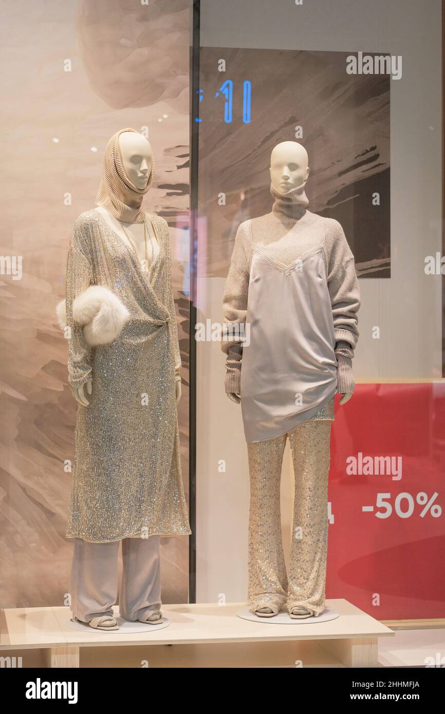 Mannequins in luxury clothes stand in a clothing store. Female