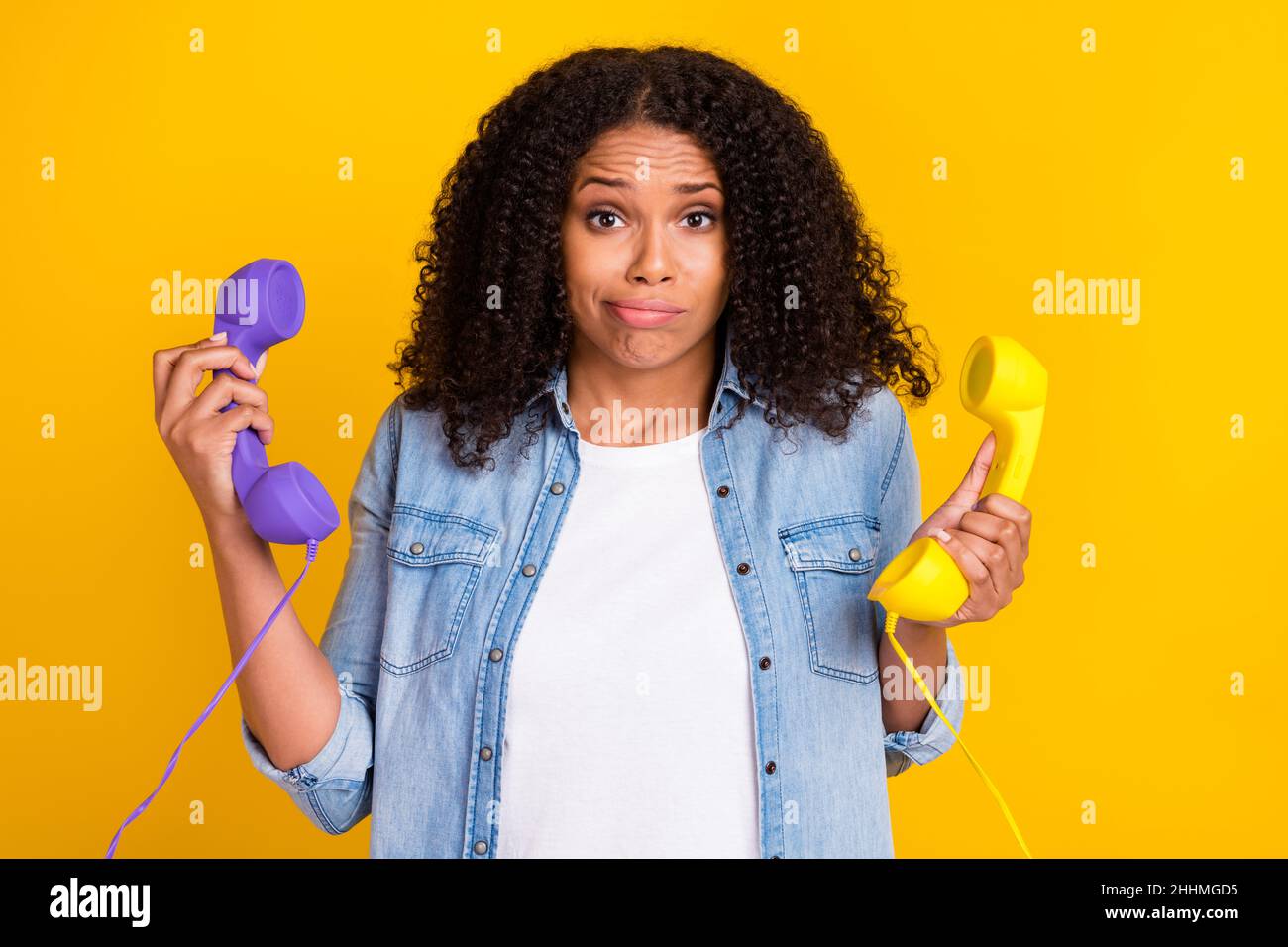 Photo of unhappy upset dark skin young woman hold hand telephone bad mood isolated on yellow color background Stock Photo
