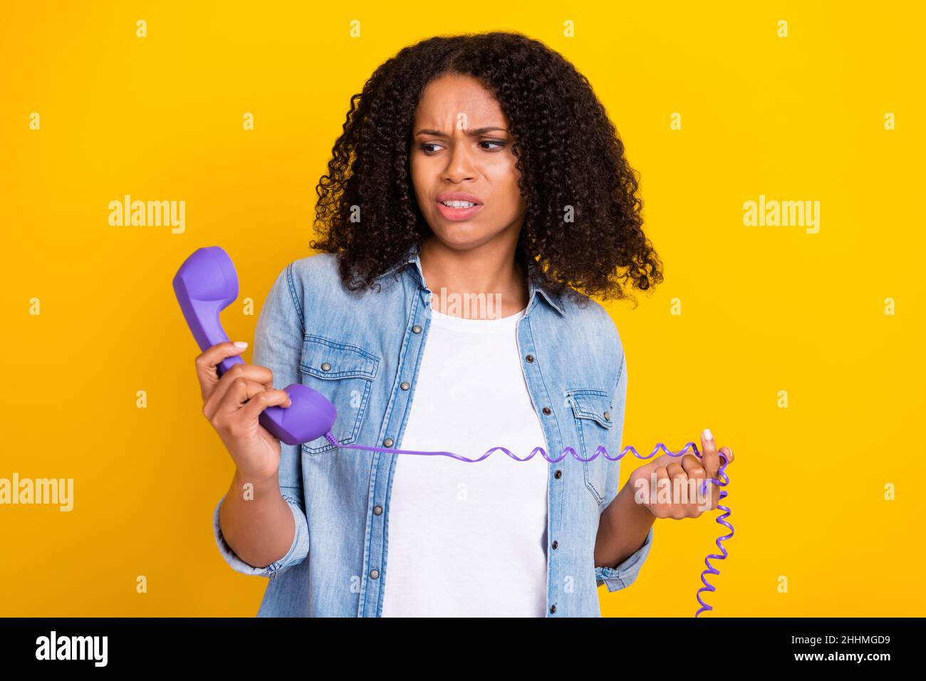 Photo of young unhappy afro american woman look phone hold dislike negative isolated on yellow color background Stock Photo