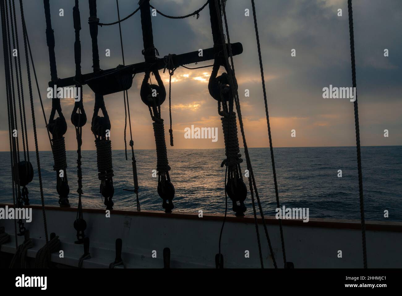 Ancient boat navigating at dawn on Mediterranean Sea. Stock Photo