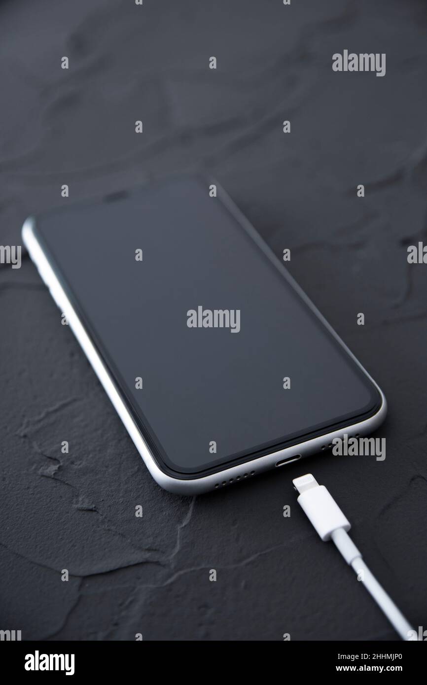 Mobile smart phone on wireless charging device on white background. Icon battery and charging progress lighting on screen.smartphones connected to pow Stock Photo