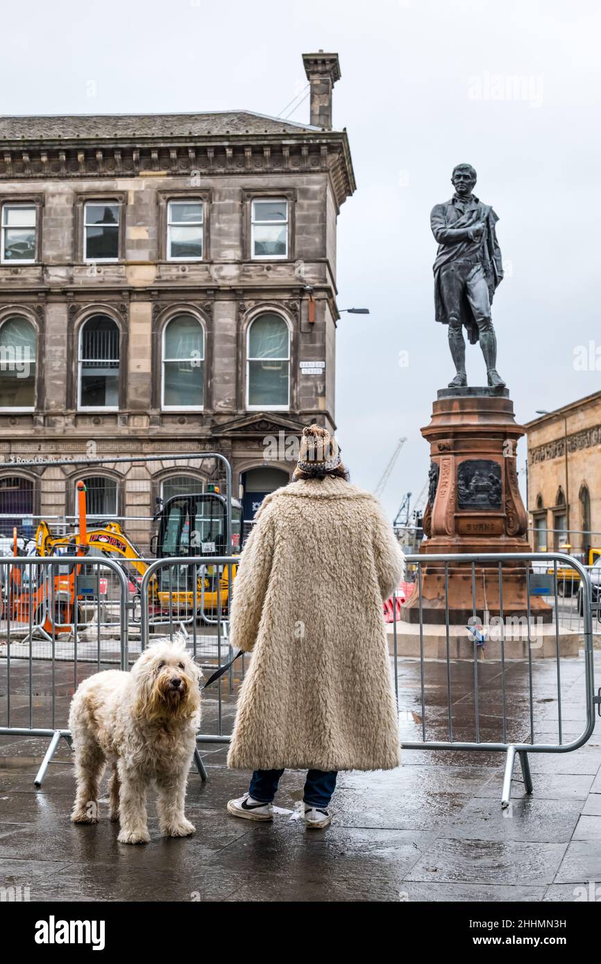 Leith, Edinburgh, Scotland, United Kingdom, 25 January 2022. Robert Burns statue unveiled: The statue, which was removed in 2019 for the Trams to Newhaven construction work, returns to Bernard Street newly restored on Burns Night. The statue was erected by the Leith Burns Club in 1898. On each side of the pedestal is a panel based on one of Burns' poems: The Cottar's Saturday Night, Hallowe'en, Death and Dr Hornbrook and The Smiddy Stock Photo